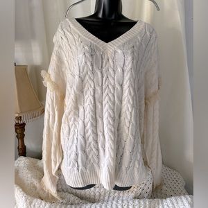Cream cable knit sweater with lace accents.